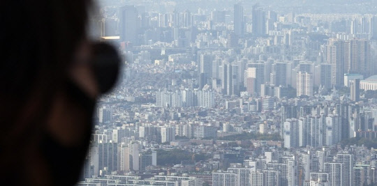 한 시민이 송파구와 강남구 일대 아파트 밀집 지역을 바라보고 있다.   연합뉴스